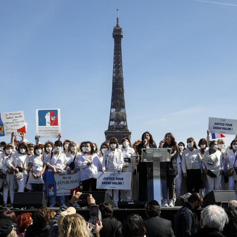 In Vordergrund Demonstranten, im Hintergrund ist der Eiffelturm zu sehen.