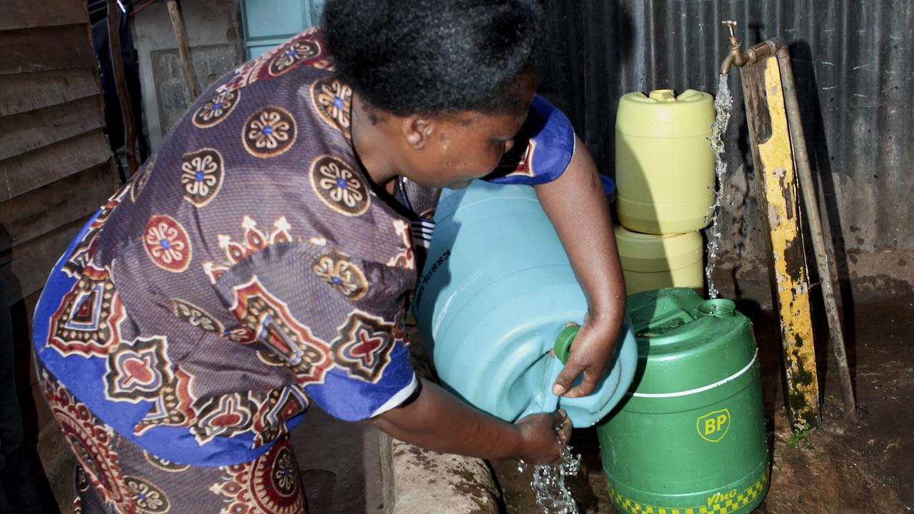 Eine Frau füllt Wasser in Plastikkanister an einem öffentlichen Brunnen in der kenianischen Hauptstadt Nairobi. Eine Frau füllt Wasser in Plastikkanister an einem öffentlichen Brunnen in der kenianischen Hauptstadt Nairobi.
