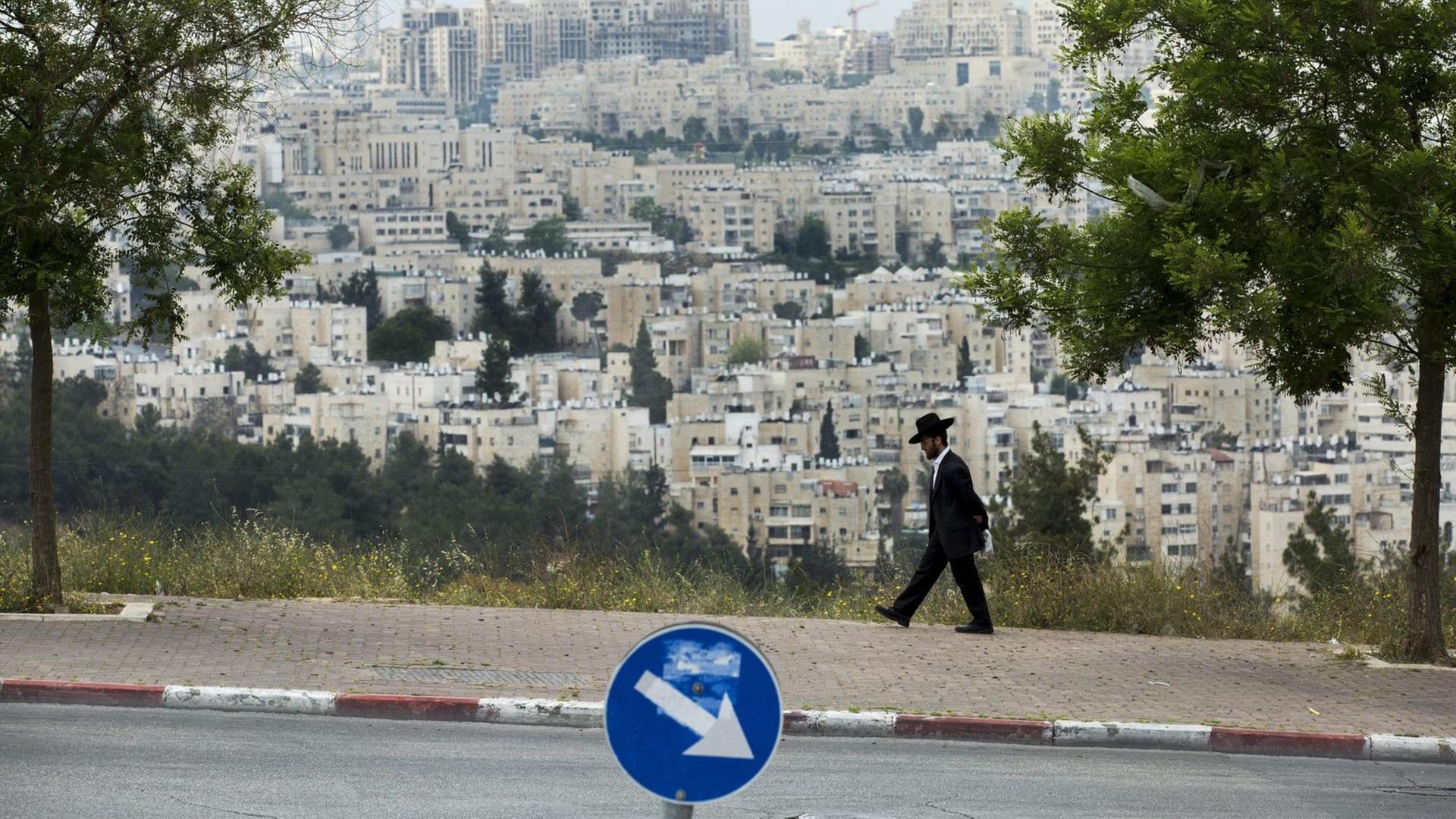 Ein ultra-orthodoxer Jude geht eine Straße im Ortsteil Ramot Shlomo in Ost-Jerusalem entlang.