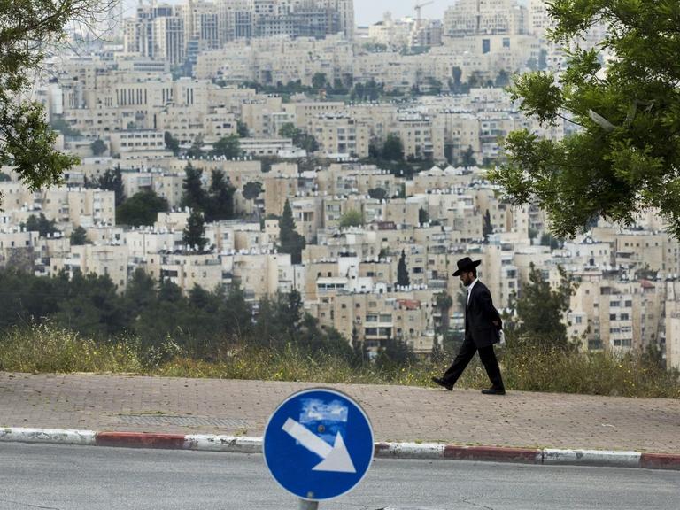 Ein ultra-orthodoxer Jude geht eine Straße im Ortsteil Ramot Shlomo in Ost-Jerusalem entlang.
