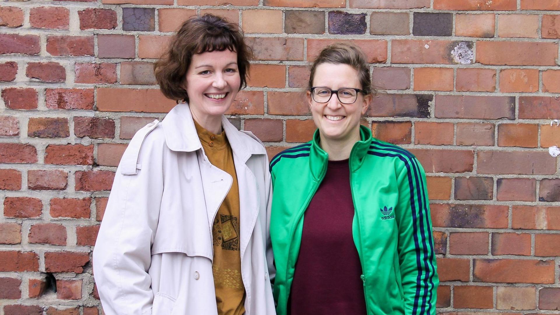 Die Regisseurin Eva-Maria Baumeister und die Stadtplanerin Isabel Finkenberger stehen vor einer Backsteinmauer. Die Regisseurin Eva-Maria Baumeister und die Stadtplanerin Isabel Finkenberger stehen vor einer Backsteinmauer.