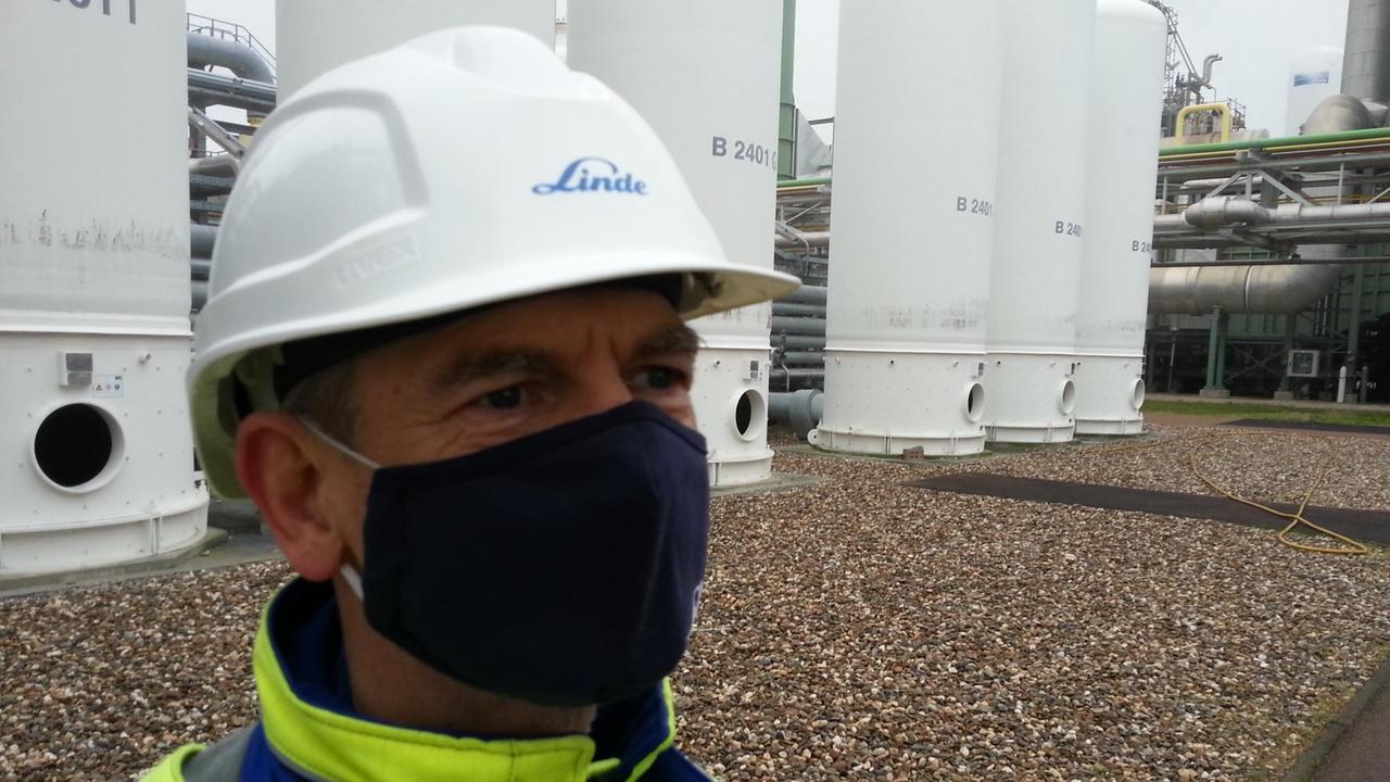Linde-Betriebsleiter Jan-Holger Lämmerhirt vor einem Tank für entmineralisiertes Wasser, dem sogenannten Deionat, einem der Ausgangsstoffe für die Wasserstoff bei der Dampfreformierung.
