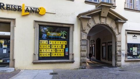 Am Fenster eines geschlossenen Reisebüros in Stuttgart steht: "Wir bleiben euch treu - bleibt uns auch treu".
