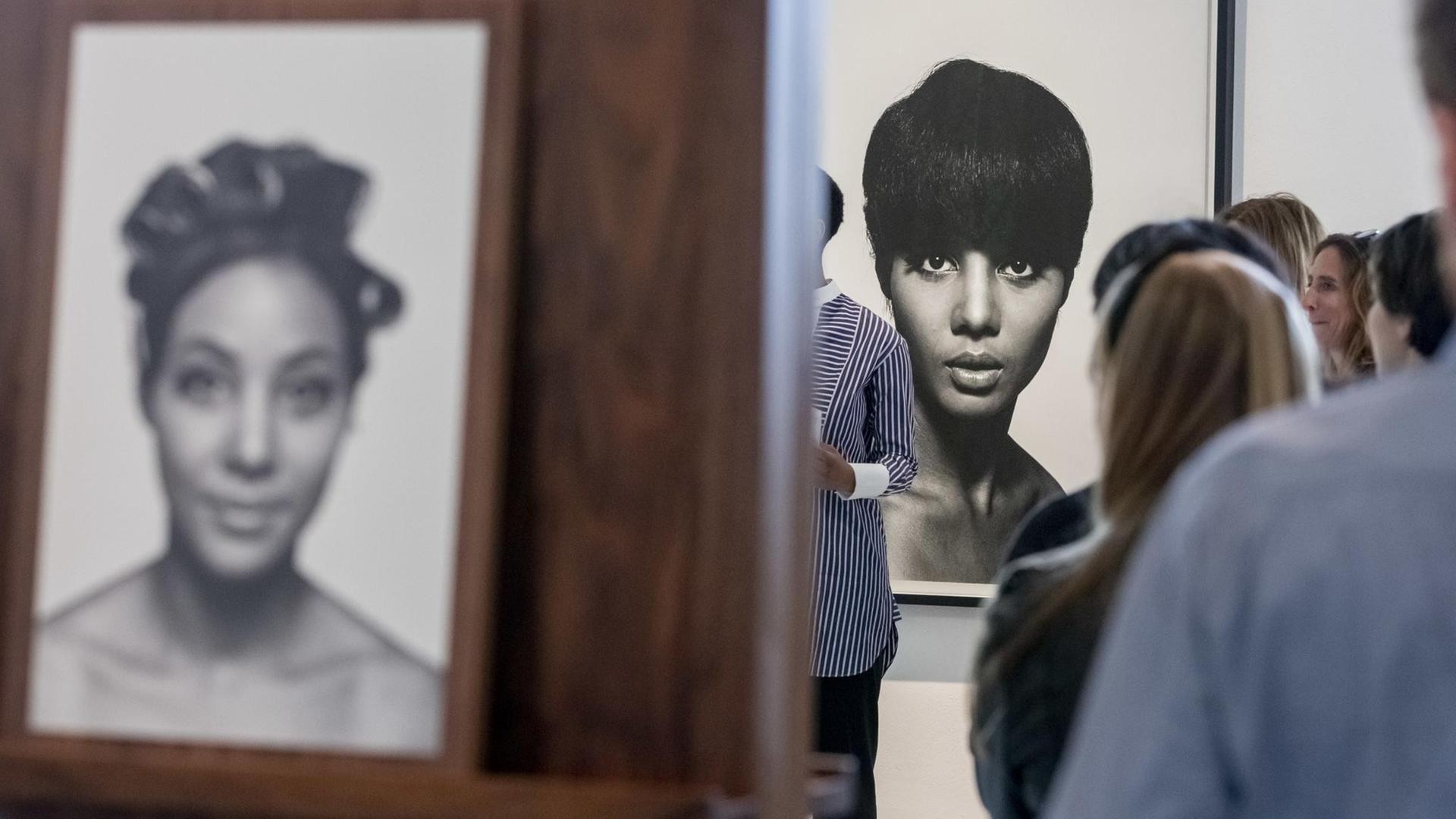 Eine Fotografie von Moneta Sleet Jr. (r.) ist in der Ausstellung "The Black Image Corporation" im Martin-Gropius-Bau hinter Besuchern einer Pressekonferenz zu sehen.