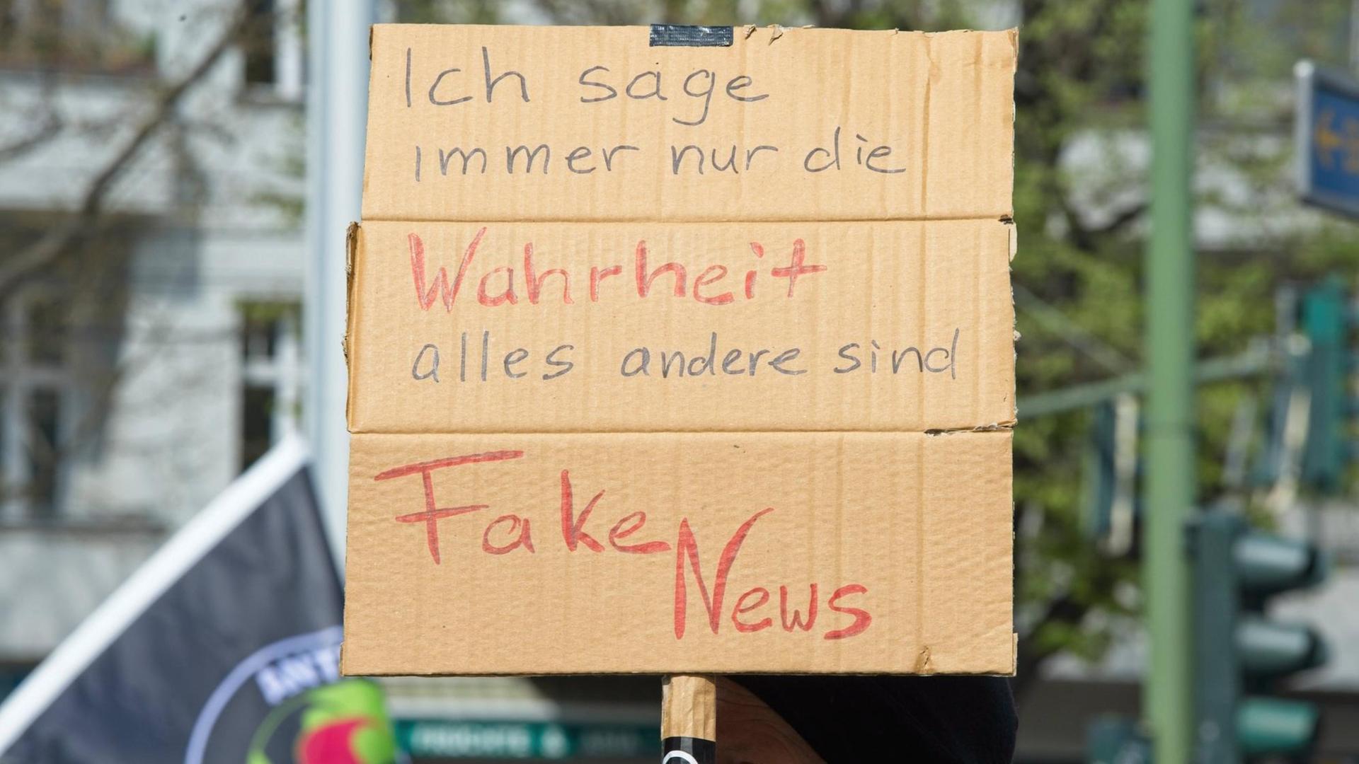 Zu sehen ist ein Plakat bei einer Demo mit dem Text "Ich sage immer nur die Wahrheit - alles Andere sind Fake News"