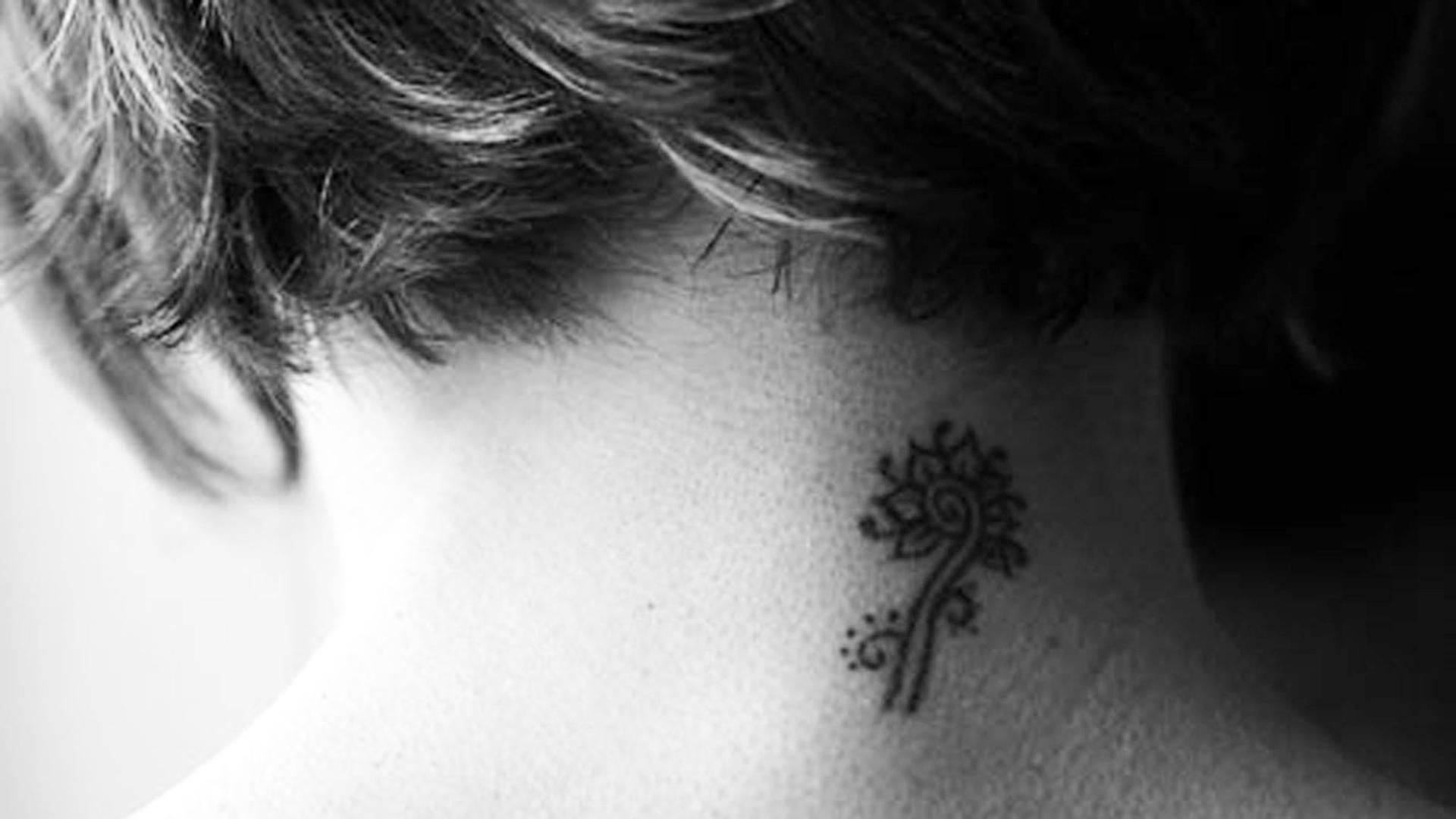 Ein Tattoo am Nacken einer Frau. Ein Tattoo am Nacken einer Frau.