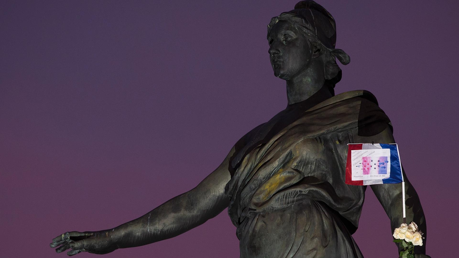 Französische Flagge vor einer Frauenstatue vor Nachthimmel Französische Flagge vor einer Frauenstatue vor Nachthimmel