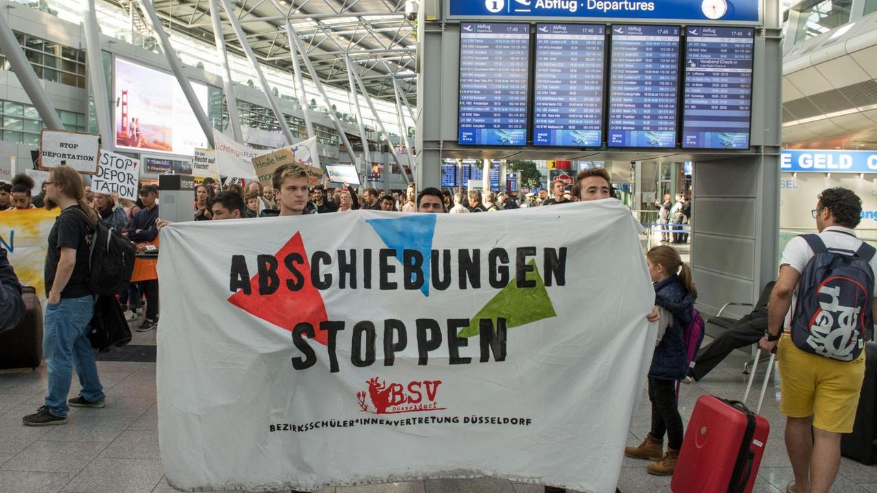 Teilnehmer einer Protestaktion gegen eine Sammelabschiebung nach Afghanistan halten ein Transparent. Teilnehmer einer Protestaktion gegen eine Sammelabschiebung nach Afghanistan halten ein Transparent.