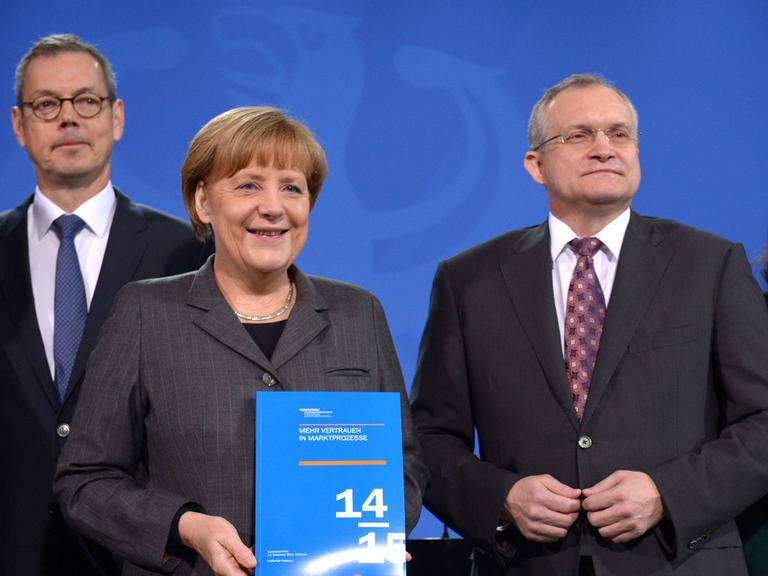Bundeskanzlerin Angela Merkel erhält den Jahresbericht der Wirtschaftsweisen, hier mit den Professoren Peter Bofinger (l.) und Christoph Schmidt.