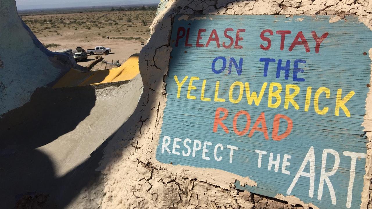 Bitte auf dem gelben Weg bleiben steht auf einem Schild oben auf dem Salvatation Mountain. Bitte auf dem gelben Weg bleiben steht auf einem Schild oben auf dem Salvatation Mountain.