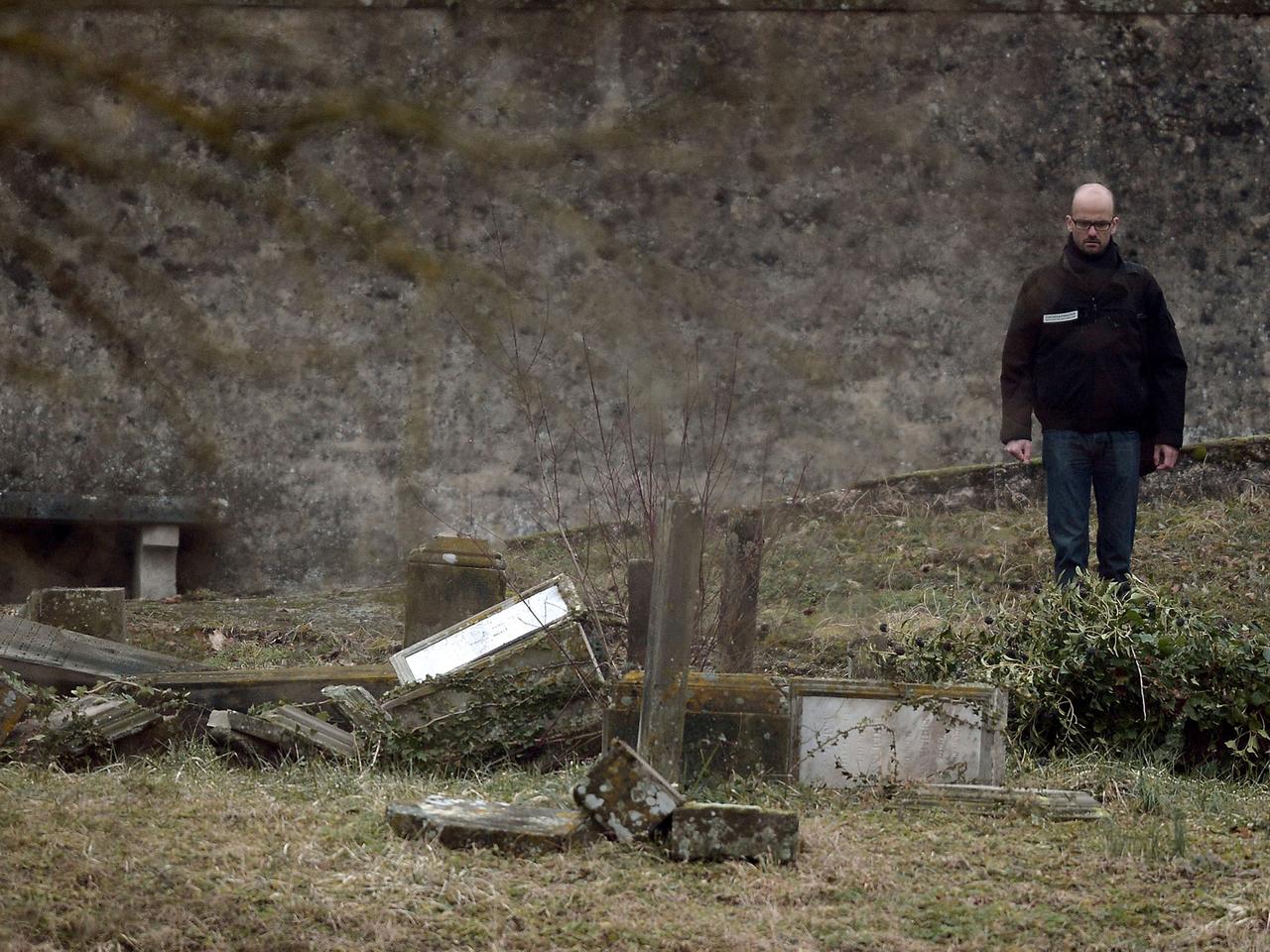 Ein Ermittler steht vor geschändeten Gräbern auf einem jüdischen Friedhof in ostfranzösischen Stadt Sarre-Union. Ein Ermittler steht vor geschändeten Gräbern auf einem jüdischen Friedhof in ostfranzösischen Stadt Sarre-Union.