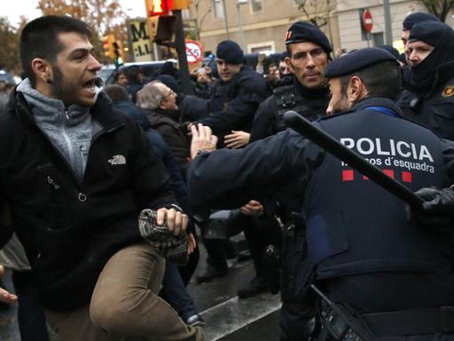 Polizisten der katalanischen Einheit Mossos d'Esquadra halten am 11.12.2017 vor dem Diözesanmuseum der Stadt Lleida in Katalonien (Spanien) wütende Demonstranten zurück.