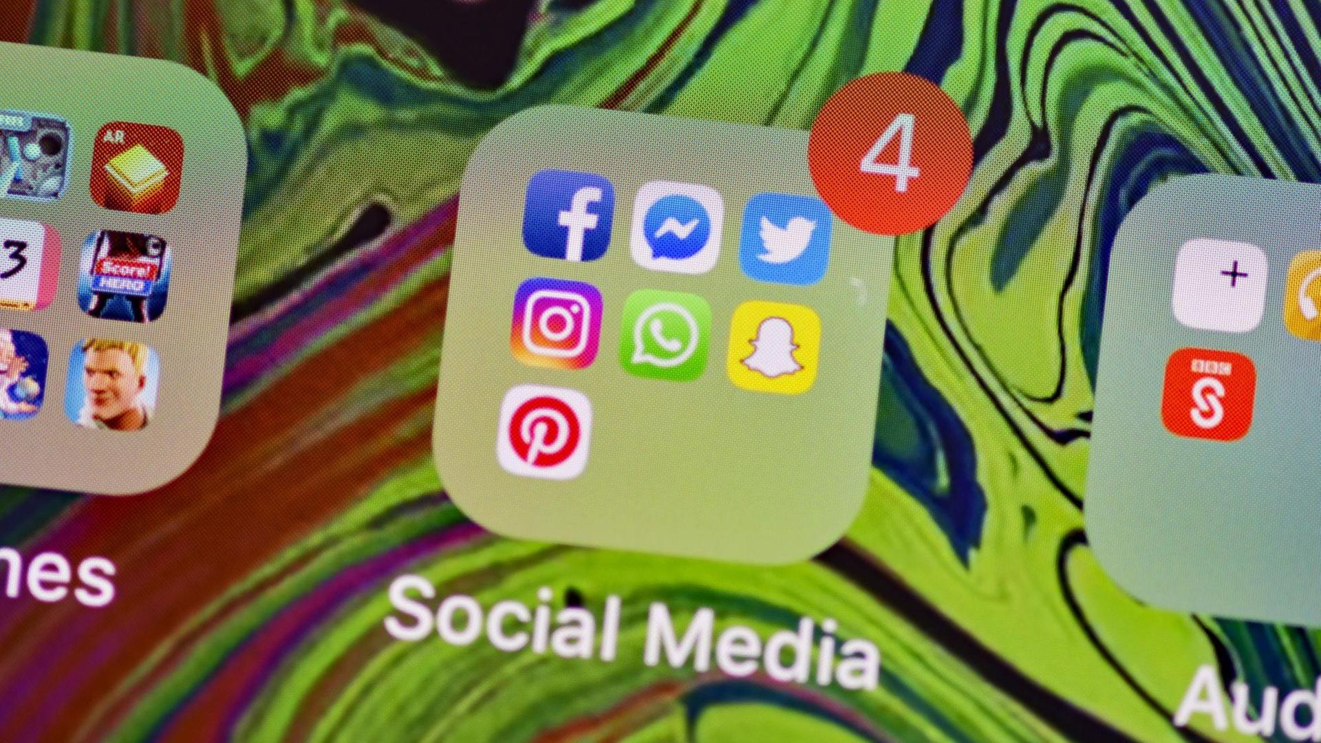 Display eines Mobilgerätes mit den Logos der Social-Media-Apps Facebook, Messenger, Twitter, Instagram, WhatsApp, Snapchat and Pinterest. Display eines Mobilgerätes mit den Logos der Social-Media-Apps Facebook, Messenger, Twitter, Instagram, WhatsApp, Snapchat and Pinterest.
