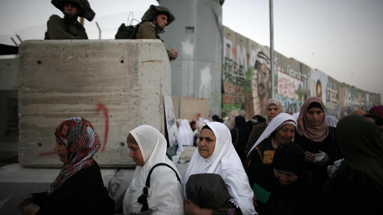 Palästinensische Frauen warten in der Schlange, um die Sicherheitskontrollen am Kalandia-Kontrollpunkt zu passieren, der von der Stadt Ramallah im Westjordanland nach Jerusalem führt. 20. August 2010 Palästinensische Frauen warten in der Schlange, um die Sicherheitskontrollen am Kalandia-Kontrollpunkt zu passieren, der von der Stadt Ramallah im Westjordanland nach Jerusalem führt. 20. August 2010