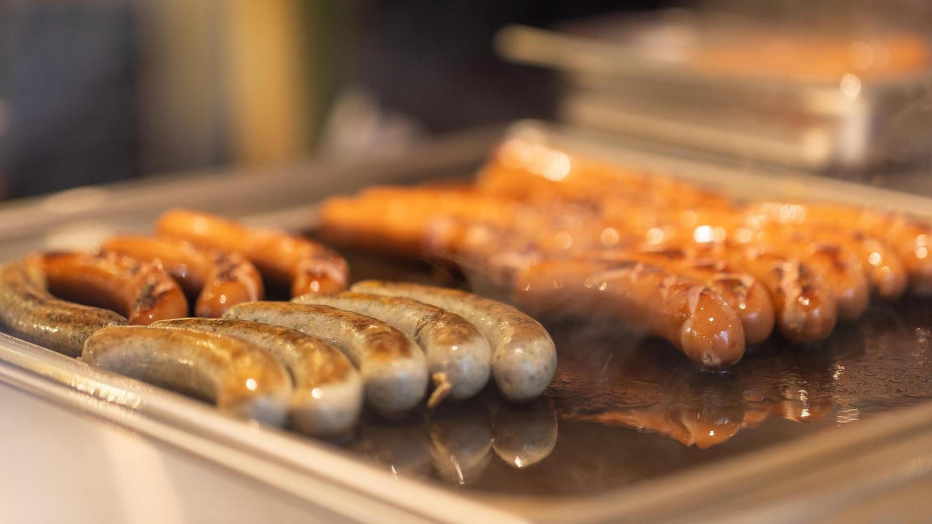 Bratwürste liegen auf einem Grill Bratwürste liegen auf einem Grill