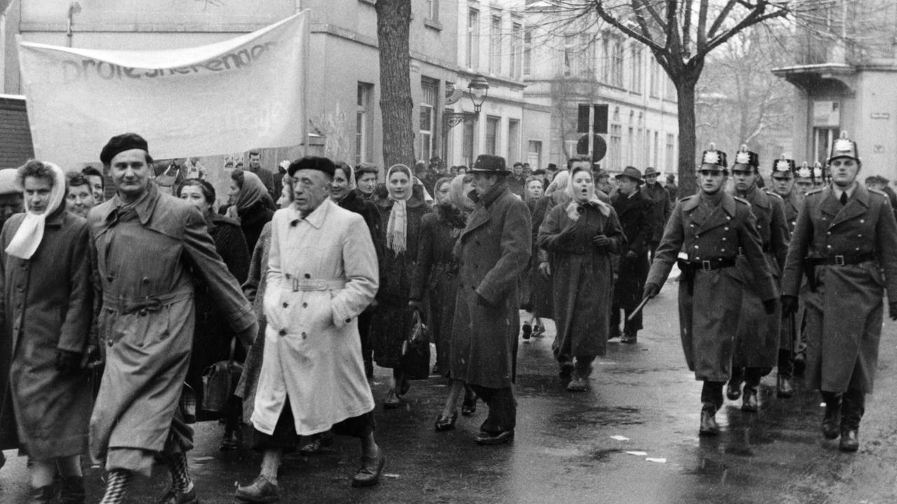 Bei einer Demonstration gegen die Wiederbewaffnung Deutschlands am 24.02.1955 in Bonn laufen Menschen mit Transparenten durch die Straßen. Bei einer Demonstration gegen die Wiederbewaffnung Deutschlands am 24.02.1955 in Bonn laufen Menschen mit Transparenten durch die Straßen.