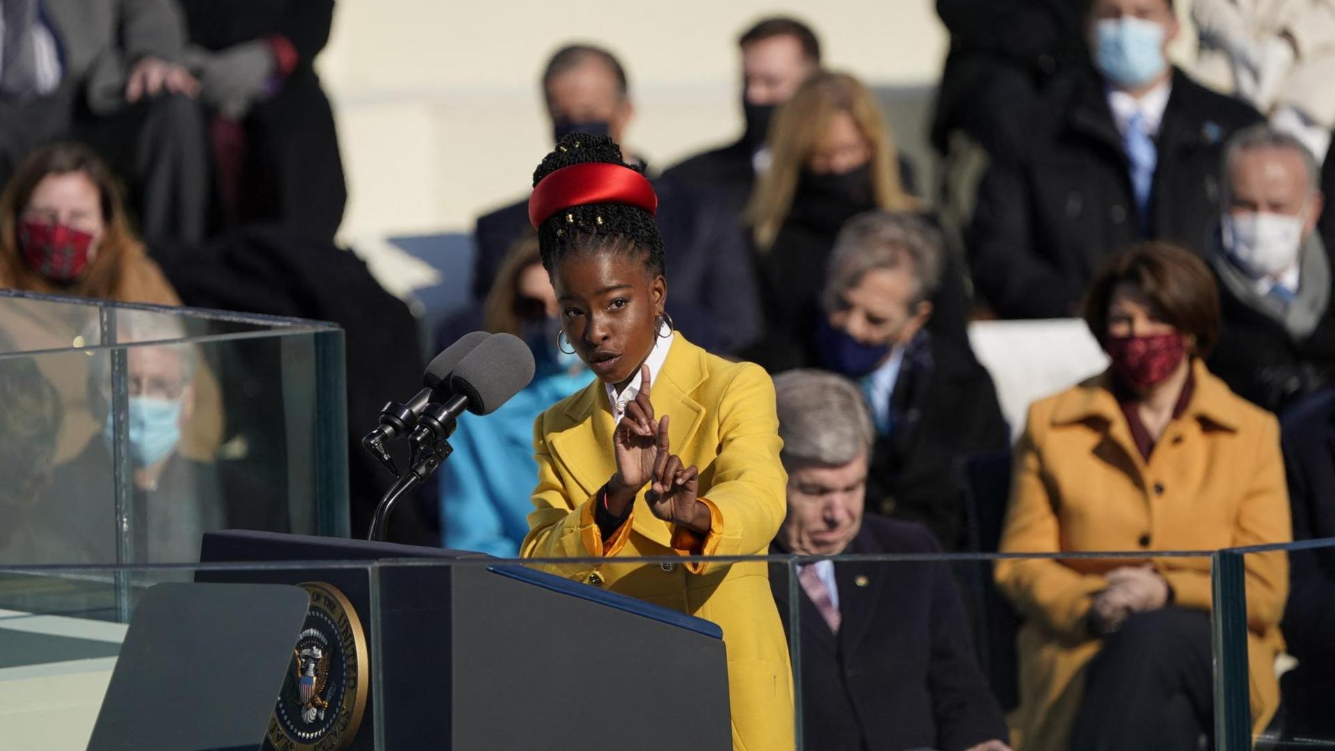 Die Lyrikerin Amanda Gorman steht am Rednerpult während der Amtseinführung von US-Präsident Joe Biden und spricht zum Publikum. Die Lyrikerin Amanda Gorman steht am Rednerpult während der Amtseinführung von US-Präsident Joe Biden und spricht zum Publikum.