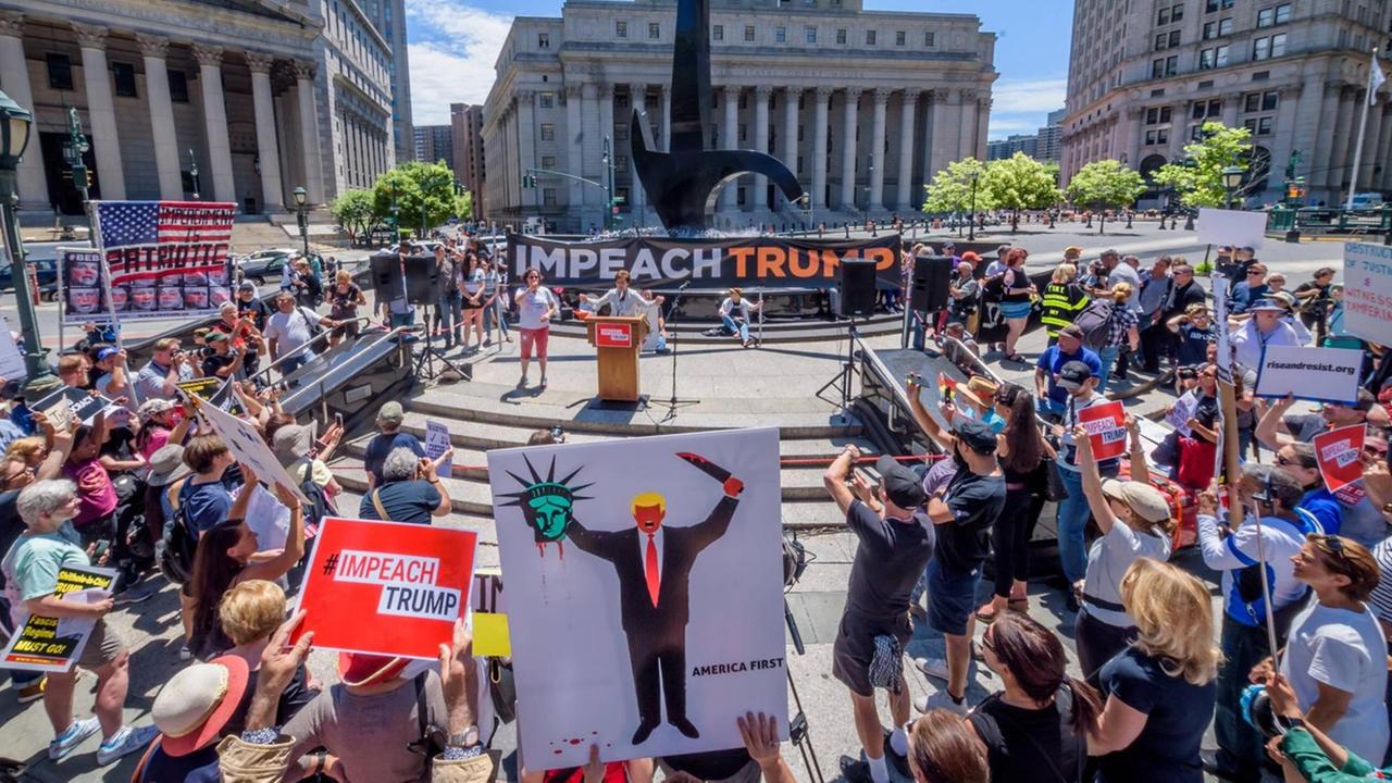 Demonstranten stehen mit Protestschildern rund um eine Rednerbühne am Foley Square in New York City. Demonstranten stehen mit Protestschildern rund um eine Rednerbühne am Foley Square in New York City.