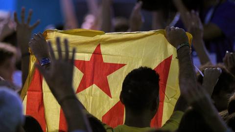 Ein Mann in Barcelona hält bei der Regionalwahl eine katalanische Flagge hoch, um für die Unabhängigkeit Kataloniens zu demonstrieren.