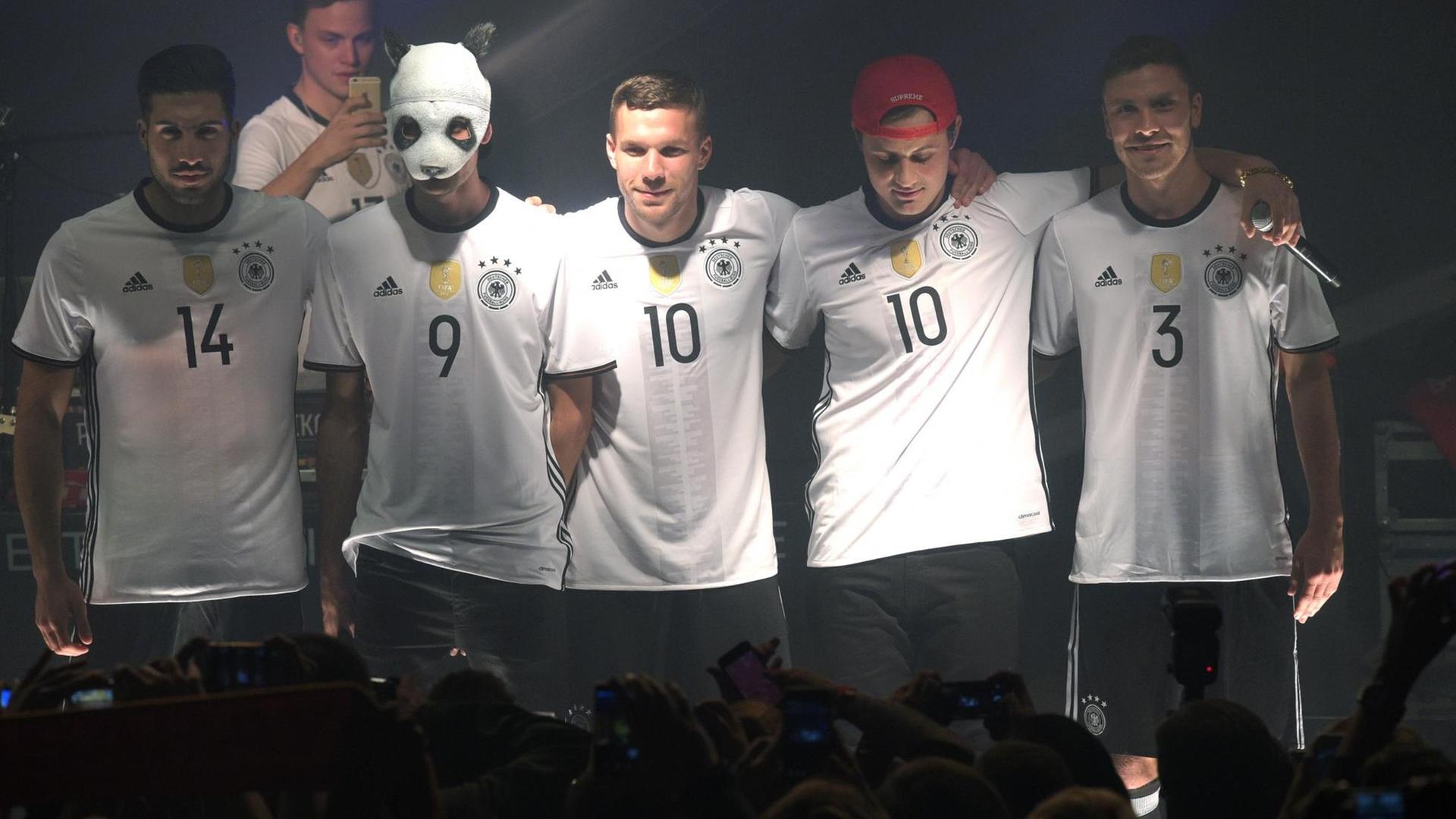 Die Fußballnationalspieler Emre Can (l), Lukas Podolski (M) und Jonas Hector (R) posieren mit Rapper Cro (2.v.l.) am 09.11.2015 in Berlin bei der Trikot-Präsentation des DFB-Ausrüsters Adidas im neuen Trikots der deutschen Nationalmannschaft für die EM 2016 in Frankreich. Die Fußballnationalspieler Emre Can (l), Lukas Podolski (M) und Jonas Hector (R) posieren mit Rapper Cro (2.v.l.) am 09.11.2015 in Berlin bei der Trikot-Präsentation des DFB-Ausrüsters Adidas im neuen Trikots der deutschen Nationalmannschaft für die EM 2016 in Frankreich.