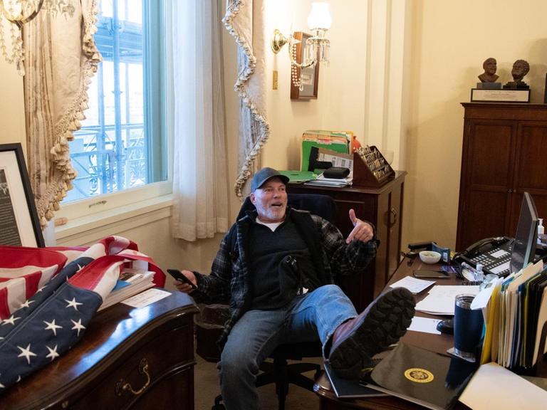 Ein Trump-Anhänger hat sich im Büro von Nancy Pelosi breitgemacht und seinen Fuß auf den Schreibtisch abgelegt.