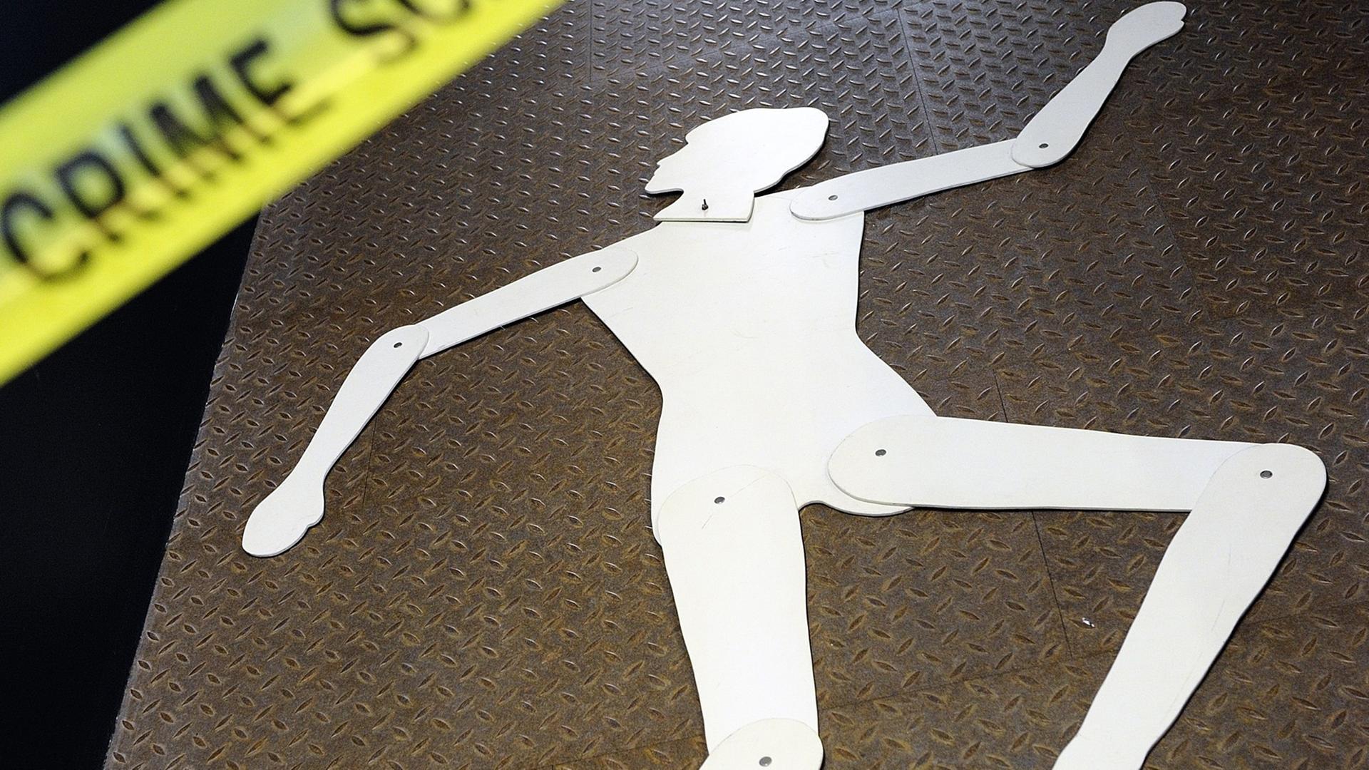 Das Bild zeigt die Silhouette einer Frau an einem Tatort, der durch ein gelbes Band mit der Schrift "Crime Scene" abgetrennt ist. Das Bild zeigt die Silhouette einer Frau an einem Tatort, der durch ein gelbes Band mit der Schrift "Crime Scene" abgetrennt ist.