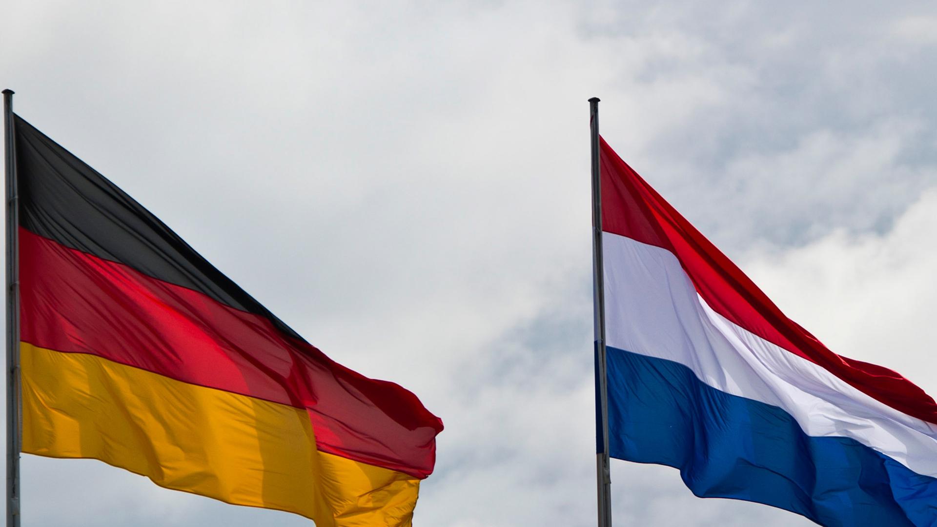 Die deutsche und die niederländische Flagge flattern im Wind. Die deutsche und die niederländische Flagge flattern im Wind.