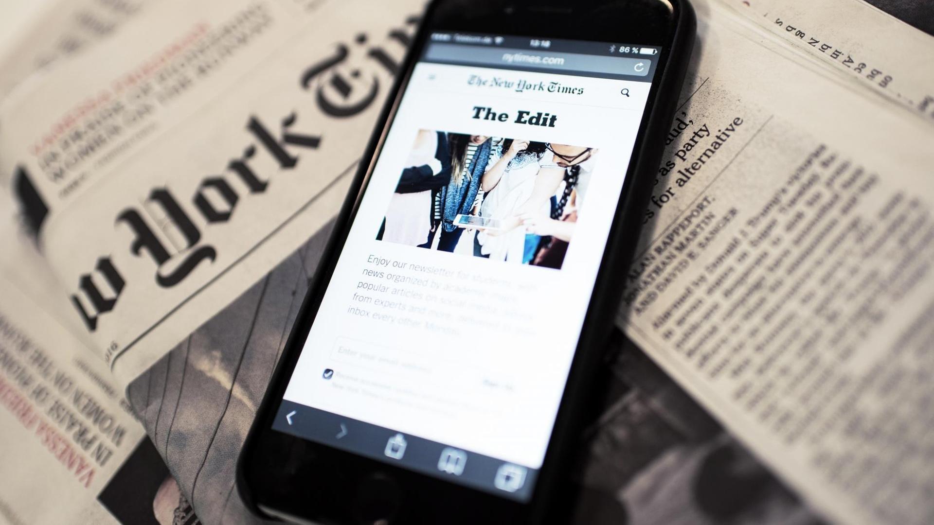 Ein Smartphone liegt auf einer Ausgabe der "New York Times" Ein Smartphone liegt auf einer Ausgabe der "New York Times"