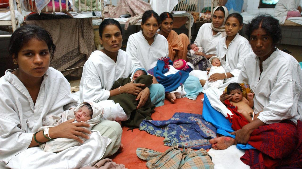 Indische Mütter sitzen mit ihren neugeborenen Babys am Dienstag (04.07.2006) auf einer Matratze auf dem Fußboden der Wöchnerinnenstation in einem Hospital in Bombay. 