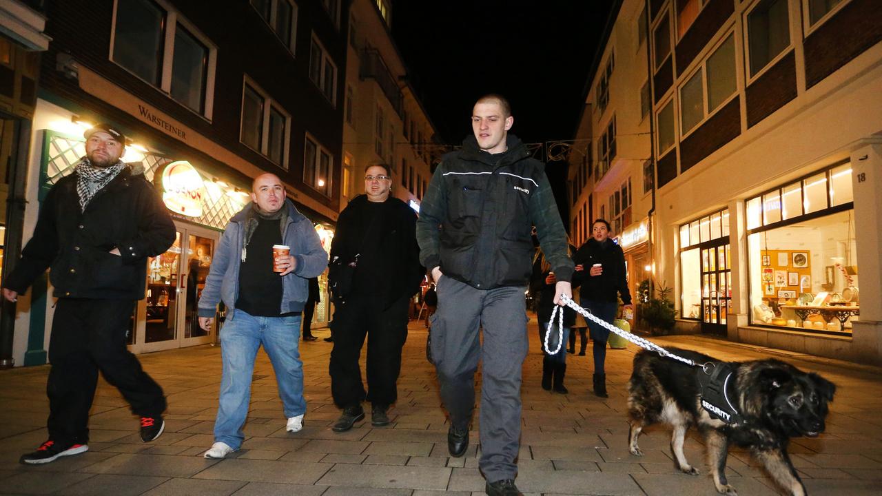 Sympathisanten einer Düsseldorfer Bürgerwehr ziehen im Dunkeln mit einem Hund durch die Altstadt. Sympathisanten einer Düsseldorfer Bürgerwehr ziehen im Dunkeln mit einem Hund durch die Altstadt.