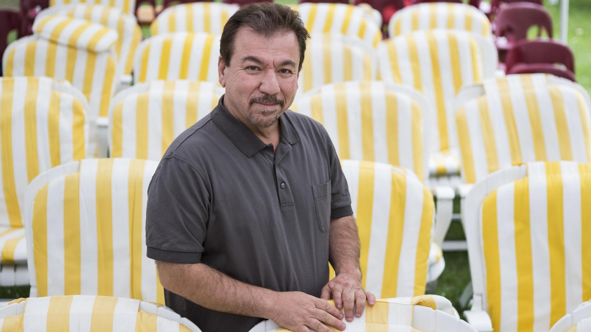 Ali Bachtyar, Autor, steht zwischen gelb-gestreiften Stühlen am 22. Internationalen Literaturfestival Leukerbad.