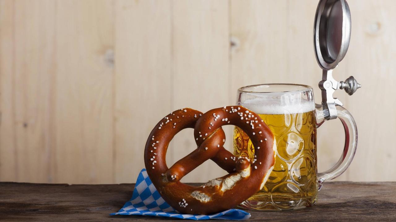 Bayerisches Bier und eine Brezel auf Holz Bayerisches Bier und eine Brezel auf Holz