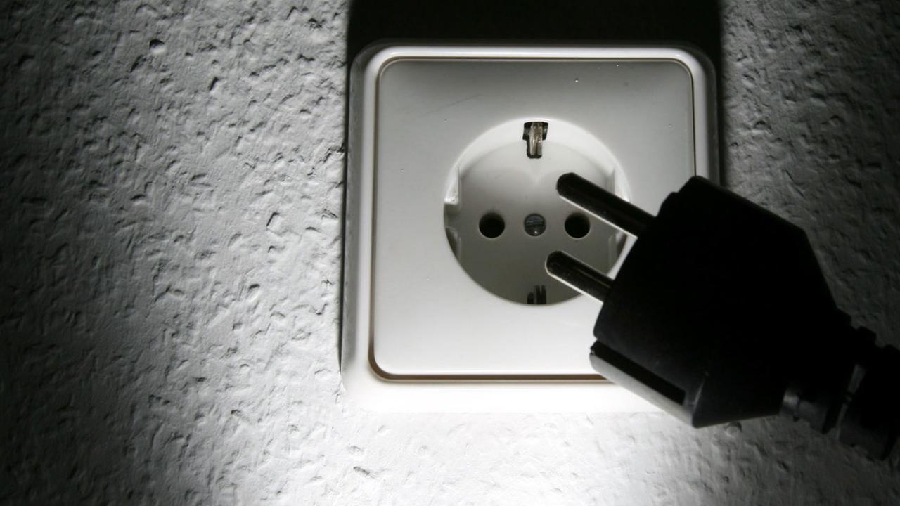 Ein schwarzer Stecker vor einer weißen 220-Volt-Steckdose aufgenommen am Dienstag (19.09.2006) in Hamburg. Ein schwarzer Stecker vor einer weißen 220-Volt-Steckdose aufgenommen am Dienstag (19.09.2006) in Hamburg.