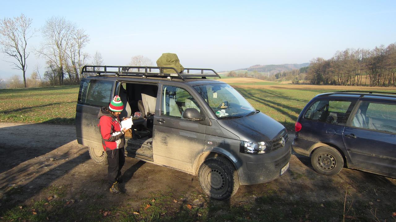 Ein VW-Kastenwagen steht auf einem Feld, vor der geöffneten Seitentür steht der Ornithologe Daniel Zunega vom Max-Planck-Institut für Ornithologie, Radolfzell. Ein VW-Kastenwagen steht auf einem Feld, vor der geöffneten Seitentür steht der Ornithologe Daniel Zunega vom Max-Planck-Institut für Ornithologie, Radolfzell.