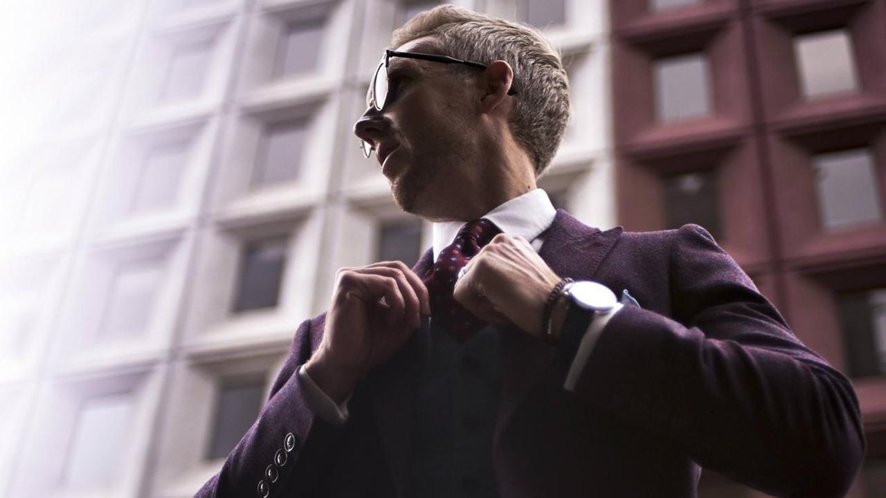 Fashion-Blogger Steve Tilbrook, im Anzug mit Armbanduhr, rückt sich seine Krawatte zurecht. Fashion-Blogger Steve Tilbrook, im Anzug mit Armbanduhr, rückt sich seine Krawatte zurecht.