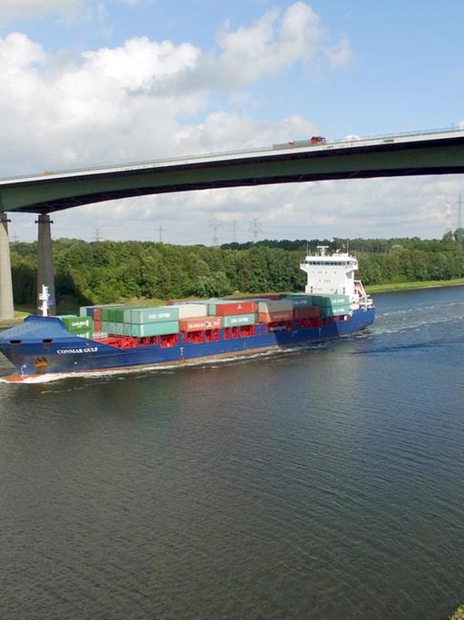 Ein Containerschiff fährt am 03.09.2015 auf dem Nord-Ostsee-Kanal in Höhe der Rader Hochbrücke der Autobahn 7 bei Rendsburg (Schleswig-Holstein). Foto: Carsten Rehder | Verwendung weltweit