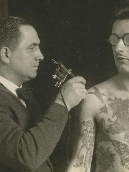 Christian Warlich tätowiert einen Mann um 1930