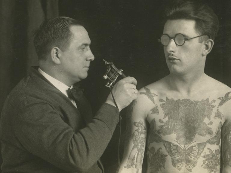 Christian Warlich tätowiert einen Mann um 1930