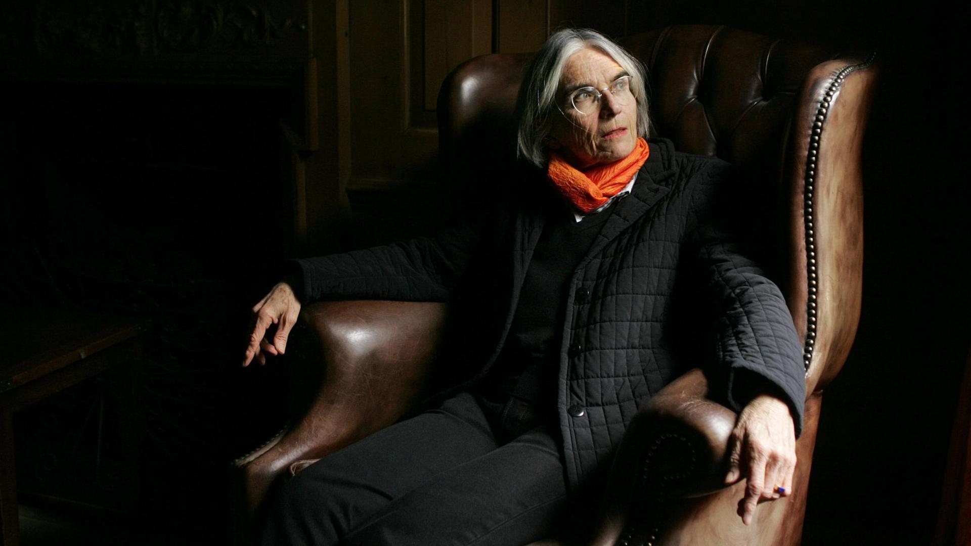 Donna Leon sitzt in einem dunklen Raum im Ledersessel und schaut zum das Licht im Fenster. Donna Leon sitzt in einem dunklen Raum im Ledersessel und schaut zum das Licht im Fenster.