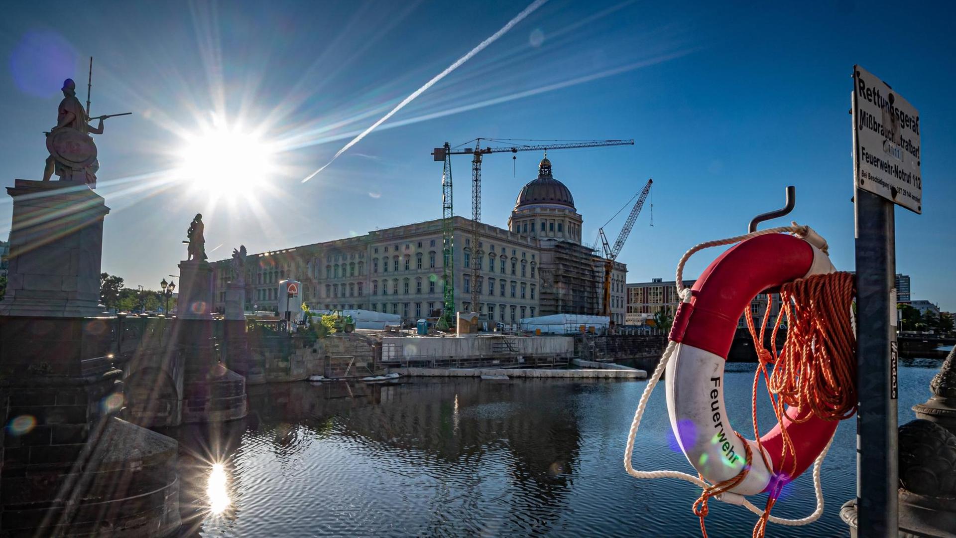 Blick auf das Humboldt Forum Berlin am Schlossplatz gegen die Sonne, im Vordergrund ein Rettungsreifen und die Spree Blick auf das Humboldt Forum Berlin am Schlossplatz gegen die Sonne, im Vordergrund ein Rettungsreifen und die Spree