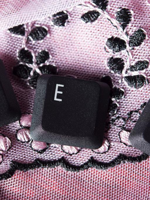 Die Tastatur-Buchstaben S, E, X liegen einzeln auf einer rosa Tischdecke.