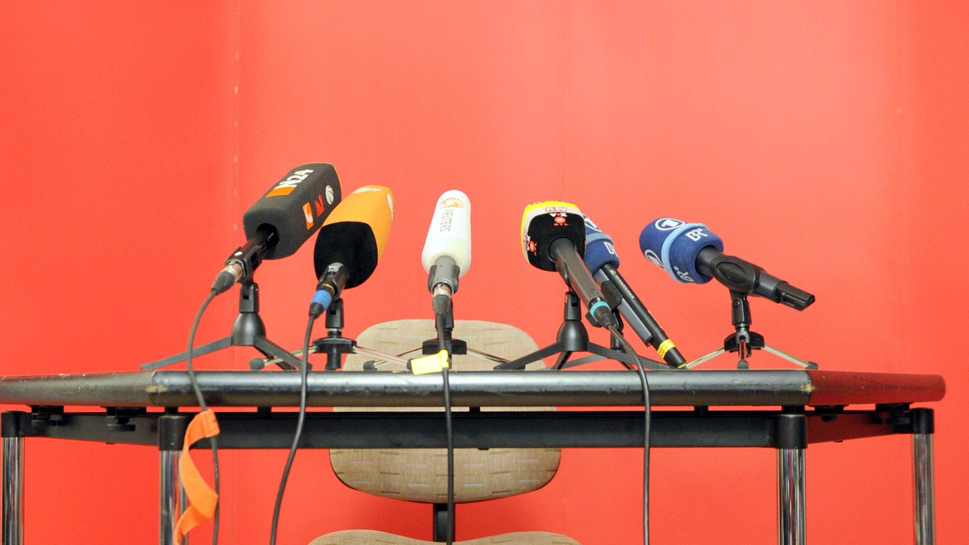 Mikrofone von Medienanstalten stehen auf einem Tisch Mikrofone von Medienanstalten stehen auf einem Tisch