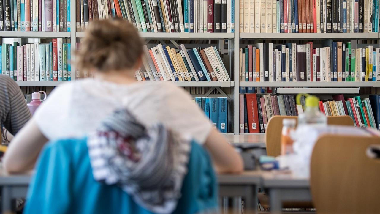 Eine Studentin lernt in der Universitätsbibliothek Tübingen. Eine Studentin lernt in der Universitätsbibliothek Tübingen.