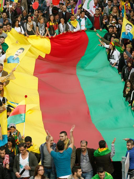 Kurden demonstrieren am 11.10.2014 in Düsseldorf (Nordrhein-Westfalen) gegen den Terror der IS und halten eine Flagge in den traditionellen Farben der Kurden, gelb, rot und grün.