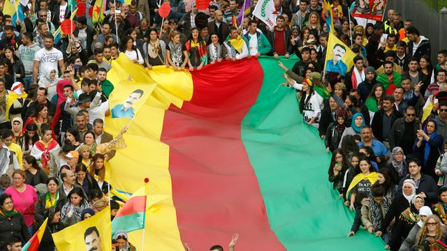 Kurden demonstrieren am 11.10.2014 in Düsseldorf (Nordrhein-Westfalen) gegen den Terror der IS und halten eine Flagge in den traditionellen Farben der Kurden, gelb, rot und grün.
