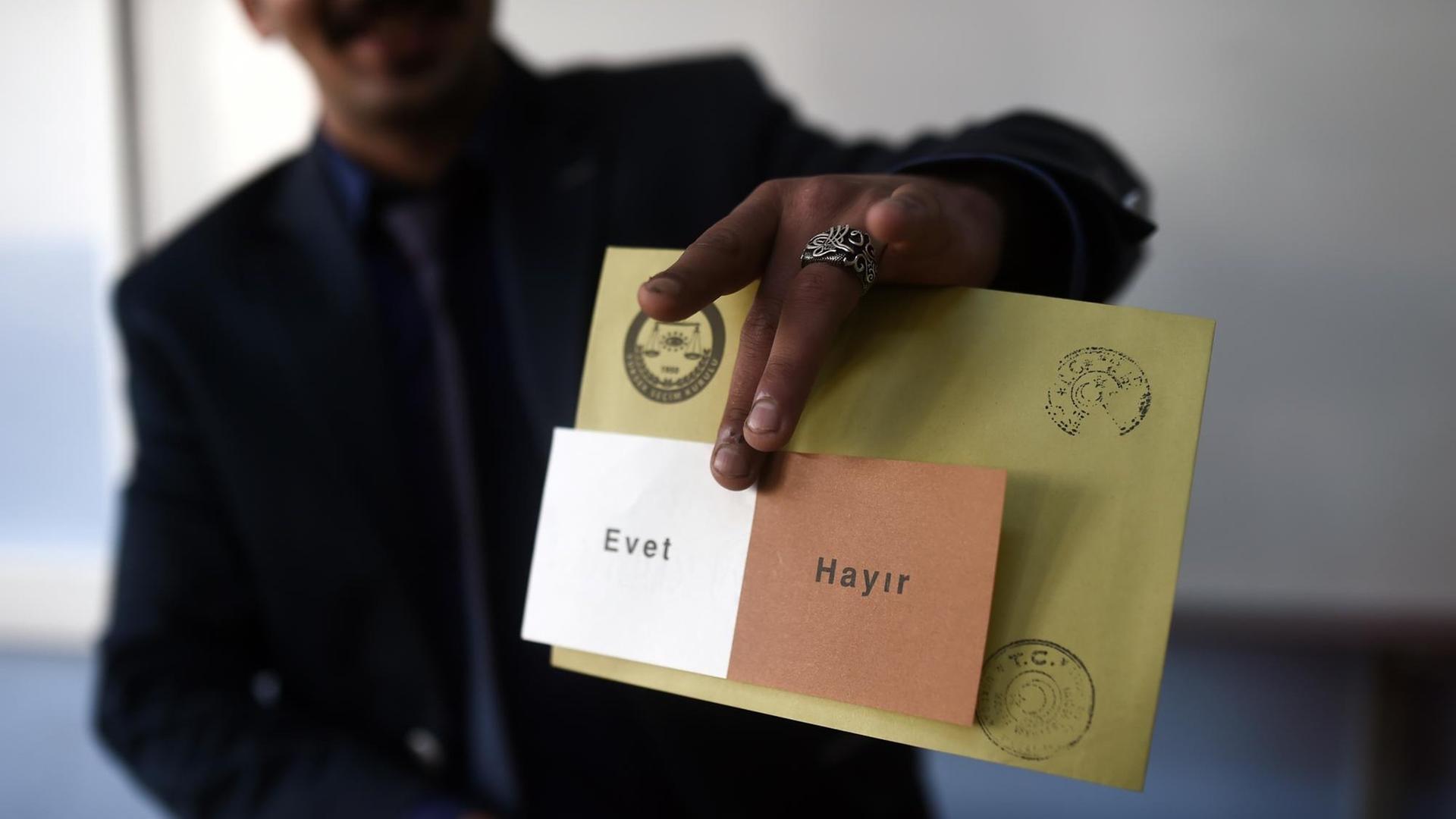 Ein Mann zeigt einen Stimmzettel mit der Aufschrift "Evet" (ja) und "Hayir" (nein). Ein Mann zeigt einen Stimmzettel mit der Aufschrift "Evet" (ja) und "Hayir" (nein).