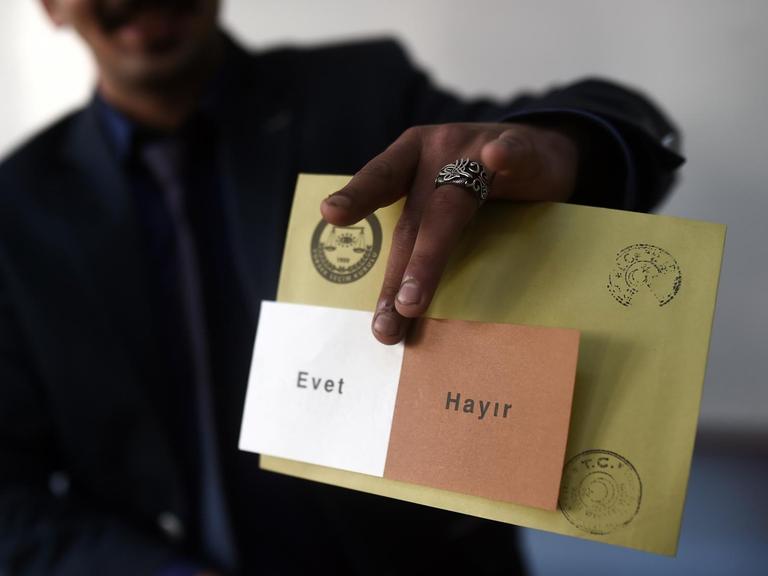 Ein Mann zeigt einen Stimmzettel mit der Aufschrift "Evet" (ja) und "Hayir" (nein).