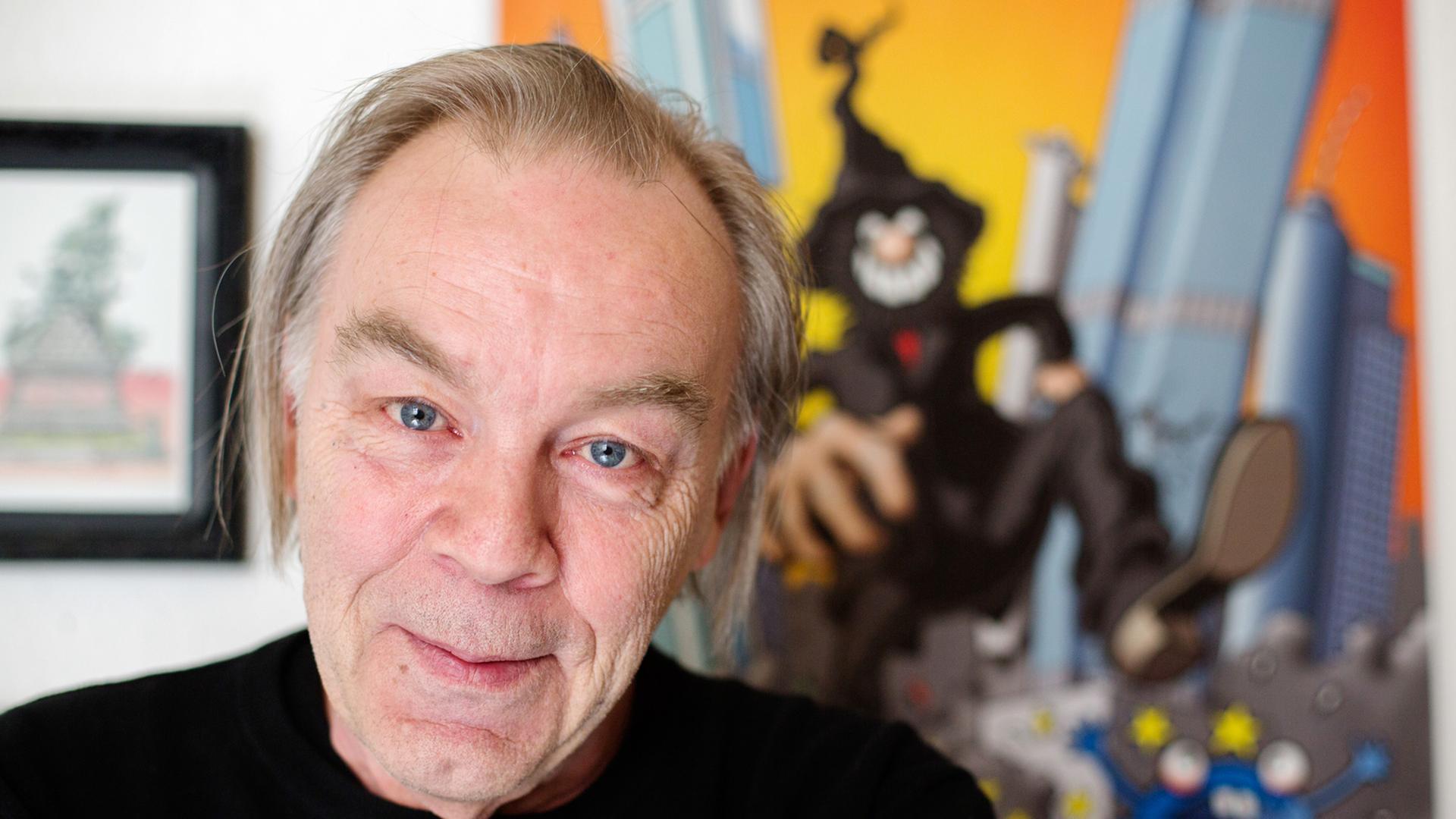 Der Comiczeichner Gerhard Seyfried steht vor einem Plakat seiner Figur _Zwille" in seiner Wohnung in Berlin-Schöneberg. Der Comiczeichner Gerhard Seyfried steht vor einem Plakat seiner Figur _Zwille" in seiner Wohnung in Berlin-Schöneberg.