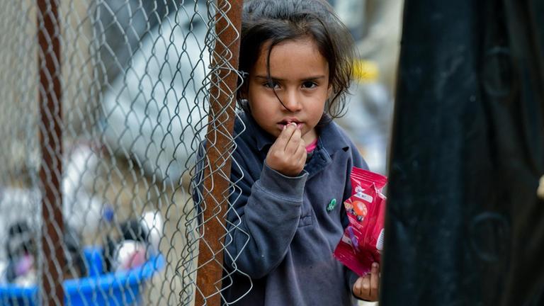 Ein Mädchen steht an einem Zaun im Flüchtlingslager Moria auf der griechischen Insel Lesbos