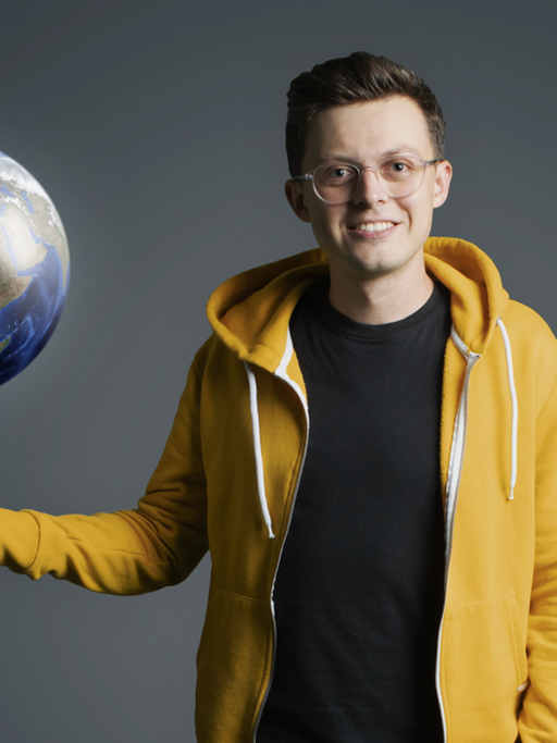 Der YouTuber und Science Influencer Jacob Beautemps neben einer Weltkugel